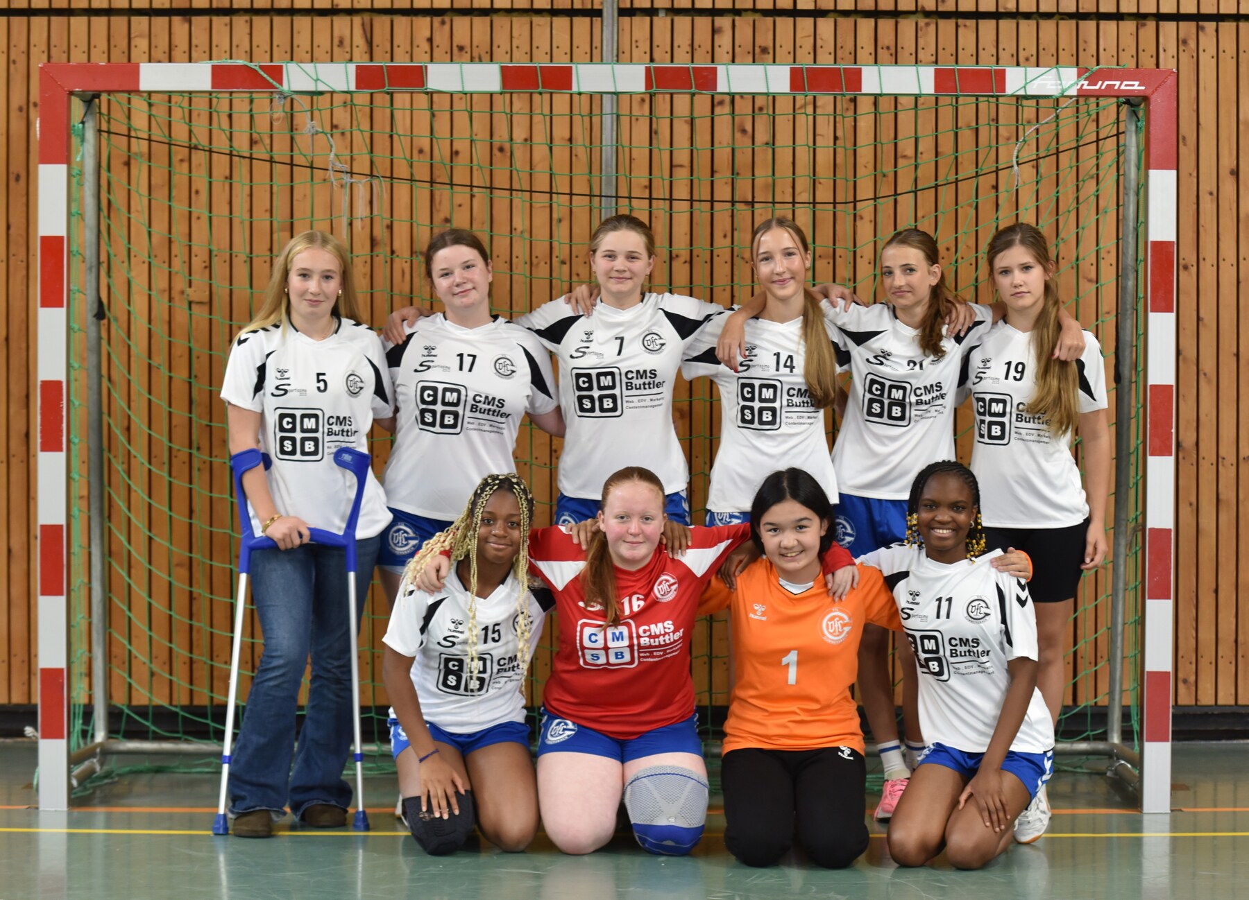 Weibliche C-Jugend des VfL Gummersbach im weißen Auswärtstrikot vor dem Handballtor