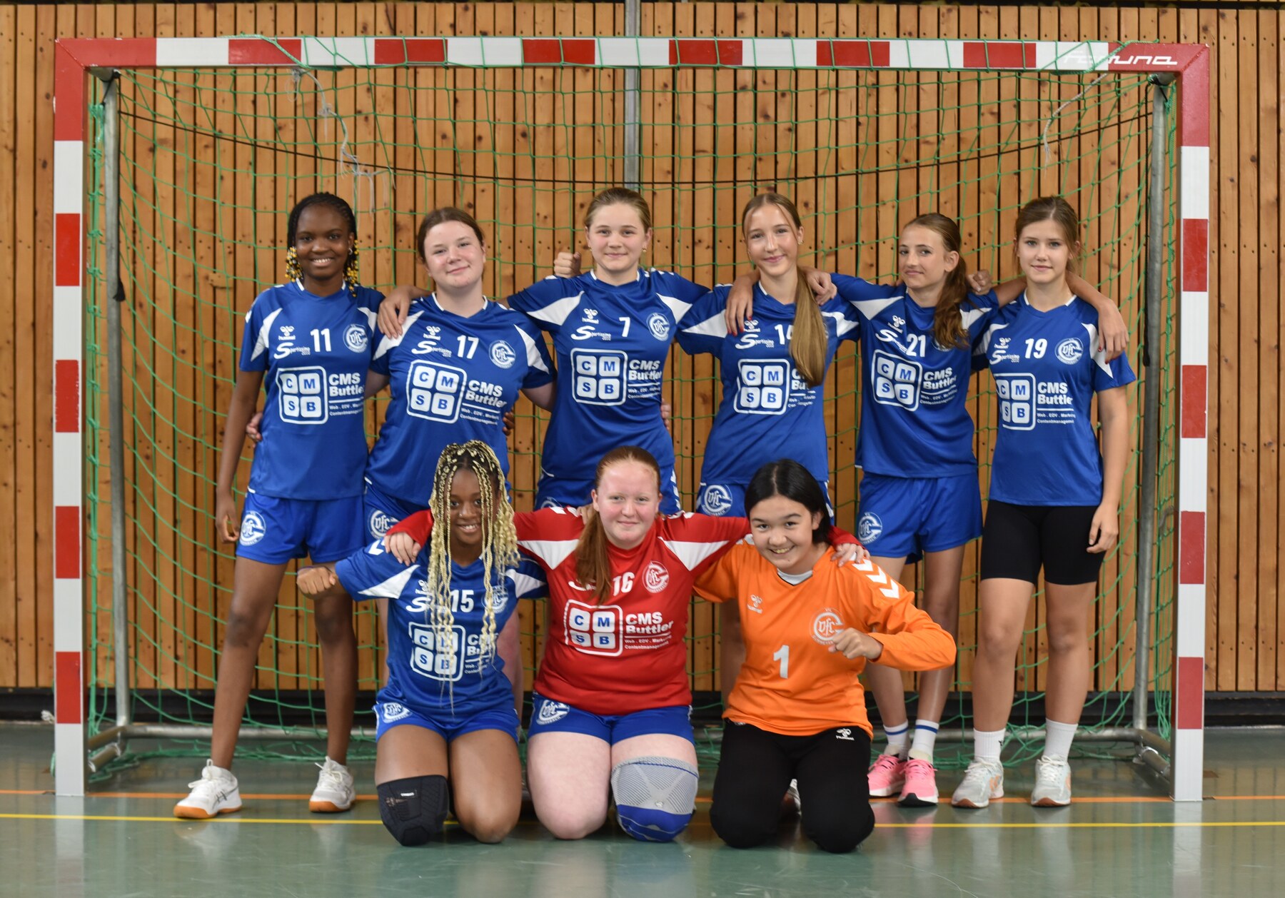 Weibliche C-Jugend des VfL Gummersbach im blauen Heimtrikot vor dem Handballtor